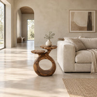 Side table with a looped ring base and two scalloped dish tops in a bright open plan living room