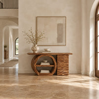 Console table with a large circular open shelf frame beside a wave carved cabinet in a bright open plan entryway