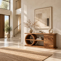 Console table with a circular shelf frame, four stacked panels and a plinth in a bright open plan entryway