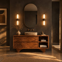 Bathroom vanity with rippled carved fronts and an arched base in a dark bathroom at golden hour