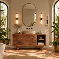 Bathroom vanity with rippled carved fronts and an arched base in a bright bathroom with arched windows and plants
