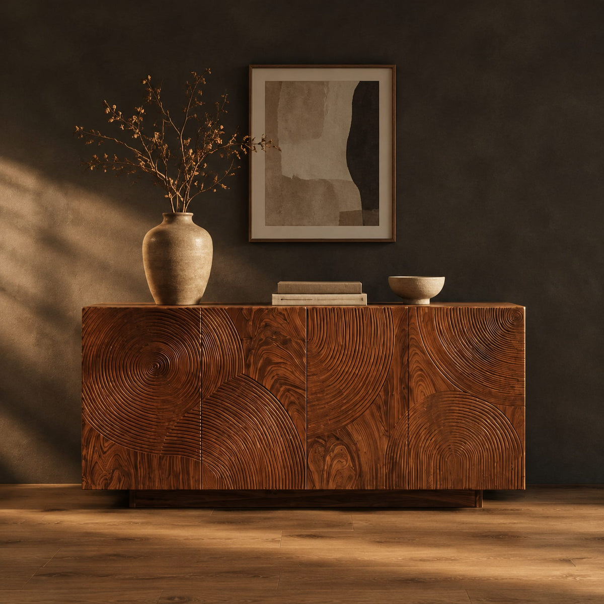 Four door sideboard carved with concentric ripple rings on a plinth base in a dark studio against a charcoal plaster wall