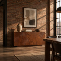 Four door sideboard carved with concentric ripple rings on a plinth base in an industrial loft dining room with exposed brick