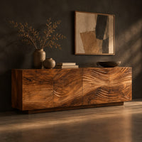 Low sideboard with four carved wave panels on a recessed plinth base, three-quarter view showing the grain