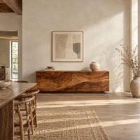 Low sideboard with four carved wave panels on a recessed plinth base in a bright open plan dining room