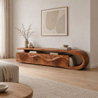 Low tv stand with ripple carved panels and a looped sweeping end in a Scandinavian living room with white walls