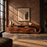 Low tv stand with ripple carved panels and a looped sweeping end in an industrial loft living room with exposed brick