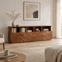 Tv stand with ripple carved front panels and four open display shelves in a Scandinavian living room with white walls