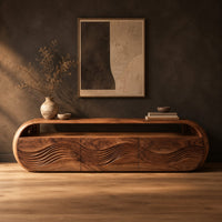 Capsule shaped tv stand with three wave carved front panels in a dark studio against a charcoal plaster wall