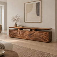 Low wooden tv stand with wave carved doors and a raised top shelf in a Scandinavian living room with white walls