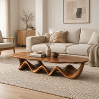 Long coffee table with a freeform oval top on a rippling wave shaped base in a Scandinavian living room with white walls