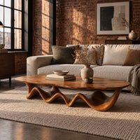Long coffee table with a freeform oval top on a rippling wave shaped base in an industrial loft living room with exposed brick