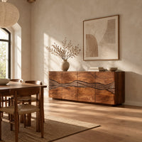 Sideboard with a winding carved band across warm grain front panels in a bright open plan dining room