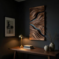 Tall wood wall relief with two black river channels above a desk in a dark study corner