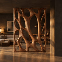 Tall wooden room divider panel with branching ribs and large oval openings in a dark open-plan living room at golden hour