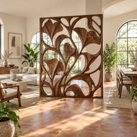 Openwork room divider with carved fan shaped leaves in a slim frame in a bright open-plan living room with arched windows and plants