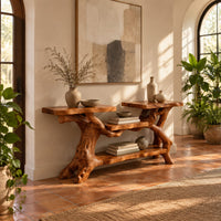 Console table with a branch root base, two slab tops and two shelves in a bright entryway with arched windows and plants