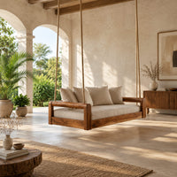 Rope hung swing with open frame arms and a deep seat cushion in a bright open plan porch