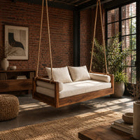 Wooden swing hung from four thick ropes with a low solid wood frame in an industrial loft porch with exposed brick