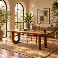 Plank top desk with a u shaped leg and two column legs in a bright home office with arched windows and plants