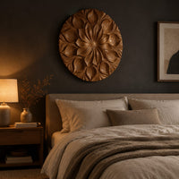 Round carved flower medallion with layers of overlapping petals above a bed in a dusk lit bedroom