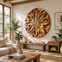 Round carved wood wall art with a radiating petal mandala pattern in a bright sunroom with green plants