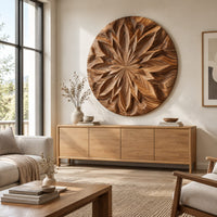 Round carved wood wall art with a radiating petal mandala pattern above a light oak sideboard in daylight