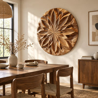 Round carved wood wall art with a radiating petal mandala pattern beside a dining table in natural light