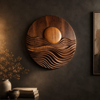 Round wall art with a raised sun over layered carved waves on a dark charcoal plaster wall