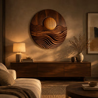 Round wall art with a raised sun over layered carved waves above a low console in an evening living room
