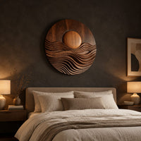 Round wall art with a raised sun over layered carved waves above a bed in a dusk lit bedroom