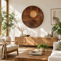 Round wall art with a raised sun over layered carved waves in a bright sunroom with green plants