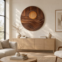 Round wall art with a raised sun over layered carved waves above a light oak sideboard in daylight