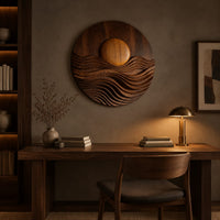 Round wall art with a raised sun over layered carved waves above a desk in a dark study corner