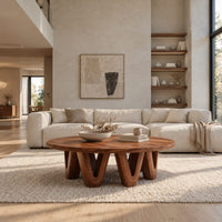 Round coffee table with a wide flat top on chunky v shaped legs in a bright open plan living room