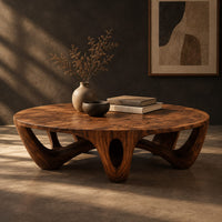 Round coffee table with arched sculpted legs and oval openings, three-quarter view showing the grain