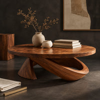 Corner detail of round coffee table with a cone foot and a tilted open loop base beside wood, brass and linen samples