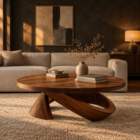 Round coffee table with a cone foot and a tilted open loop base in a dark living room at golden hour