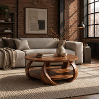 Round coffee table with crescent shaped legs and a round lower shelf in an industrial loft living room with exposed brick