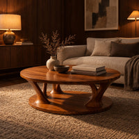 Circular coffee table with flared legs standing on a low base disc in an evening living room with walnut wall paneling