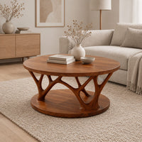 Circular coffee table with forked antler shaped legs above a wide disc base in a Scandinavian living room with white walls