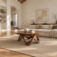 Round coffee table with a thick top and an interlaced looping wood base in a bright open plan living room