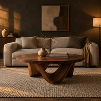 Round coffee table with a low swooping arch base in a dark living room at golden hour