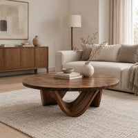 Round coffee table with a low swooping arch base in a Scandinavian living room with white walls