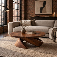 Round coffee table with a thick top and a tilted wedge base in an industrial loft living room with exposed brick