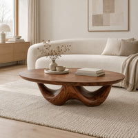 Round coffee table with a thick top on a sculpted base with two arches in a Scandinavian living room with white walls