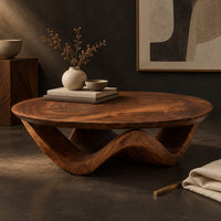 Corner detail of round coffee table with a wavy ribbon base and swirled wood grain beside wood, brass and linen samples