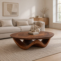 Round coffee table with a wavy ribbon base and swirled wood grain in a Scandinavian living room with white walls