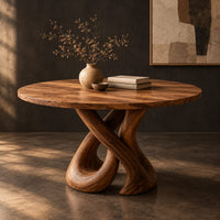 Corner detail of round dining table on a sculpted base of two crossing wooden loops beside wood, brass and linen samples