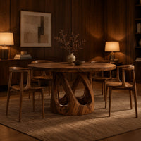 Round dining table on a pedestal of crossing curved struts in an evening dining room with walnut wall paneling